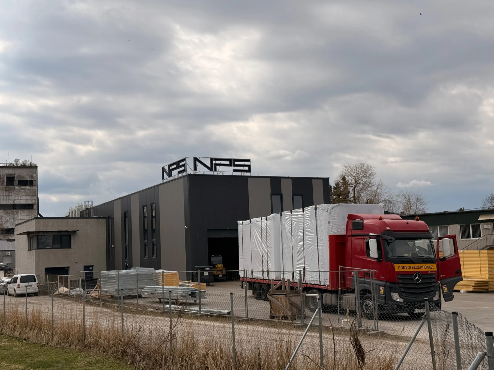 Truck with wrapped building components outside the NP5 factory